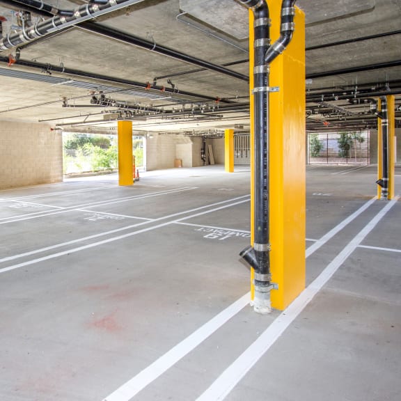 an empty parking lot with yellow poles in a building