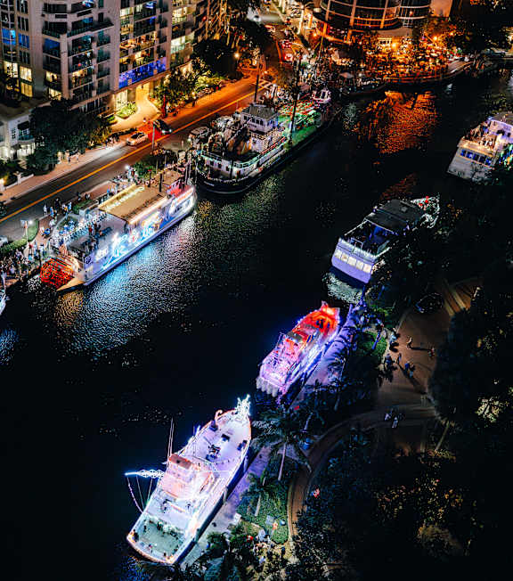 A nighttime view of a city with boats docked in the water.