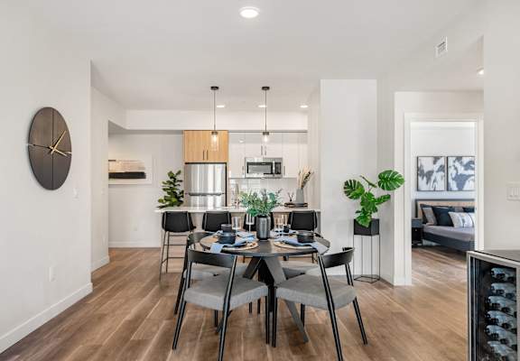 a dining room and kitchen area with a table and chairs