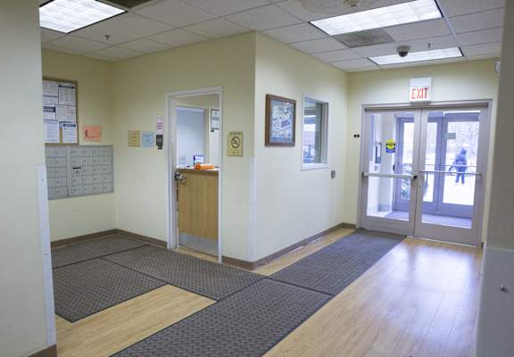 a view of a hallway in a hospital with doors and a counter