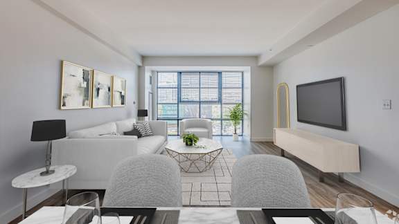 A modern living room with a grey sofa, a white coffee table, and a flat screen TV.