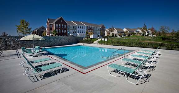 a swimming pool with lounge chairs around it and a building in the background