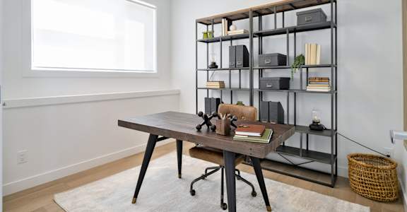 A room with a desk and a shelf with various items on it.