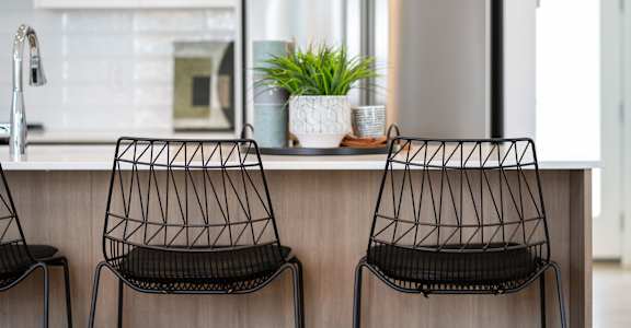 Two black chairs are placed in front of a kitchen counter.