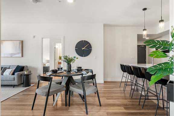A modern dining room with a large table and chairs.at Podium Apartments, Calgary, AB