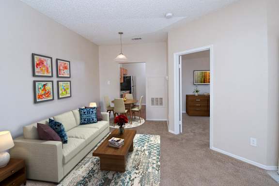 A living room with a couch, chairs, and a coffee table.