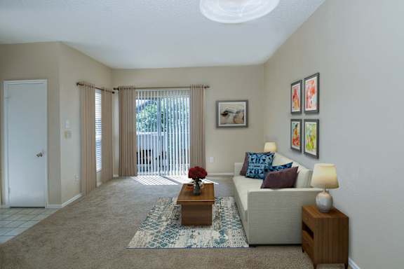 A living room with a couch, a coffee table, and a painting on the wall.