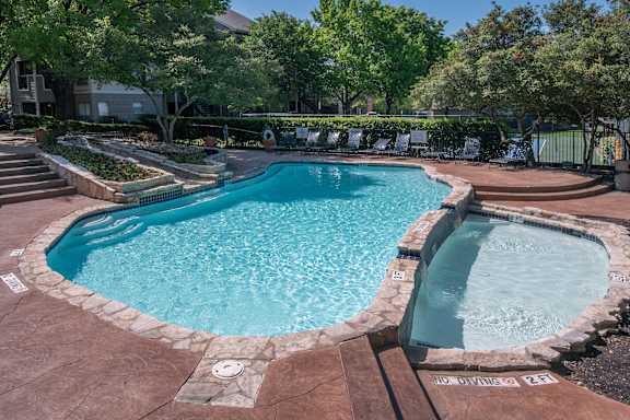 A small pool with a hot tub in the middle of it.