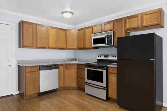 a kitchen with wood cabinets and black appliances