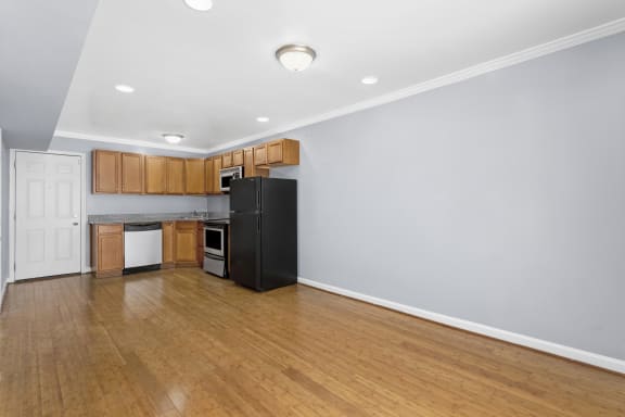 a kitchen with wood floors and wooden cabinets