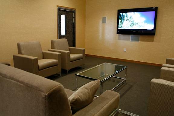 A living room with a glass coffee table and a television mounted on the wall.at 66 Main, New York, 10701