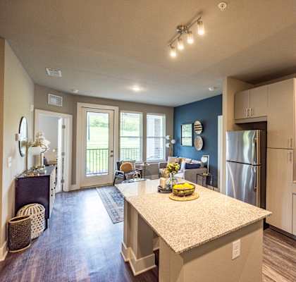 A kitchen with a refrigerator, oven, and microwave.