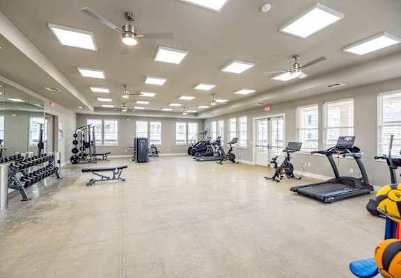 A spacious gym with a variety of equipment including treadmills, weights, and exercise machines.