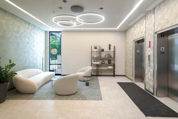A modern waiting area with white furniture and a plant.