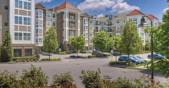A large building with a parking lot in front of it. at Vermella Lyndhurst apartments, Lyndhurst, NJ, 07071