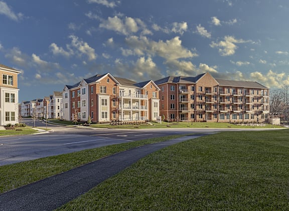 A row of new apartment buildings are shown with a road in front of them.