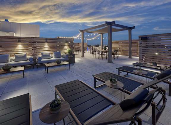 a rendering of a rooftop terrace with couches and tables