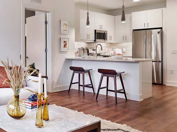 A kitchen with white cabinets and a stainless steel refrigerator.