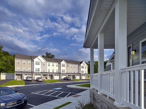 a rendering of an apartment complex with cars parked in a parking lot