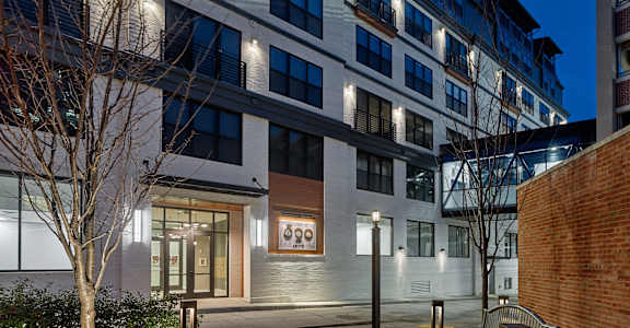 an apartment building at night with a sidewalk and benches at 520 Lofts, Allentown, Pennsylvania