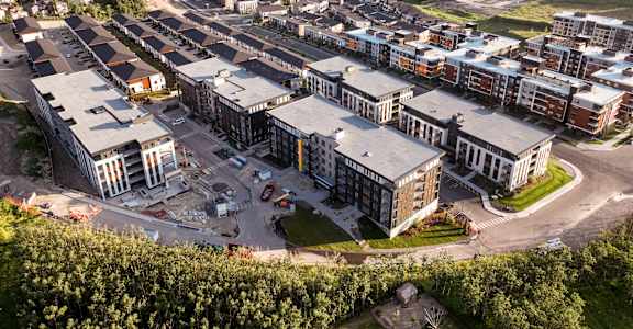A large building complex with a parking lot in front.