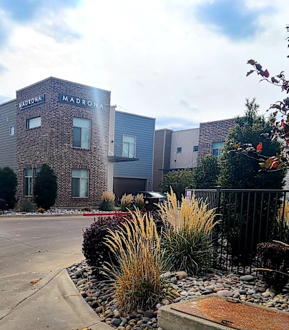 a picture of the front of a building with a garden in front of it