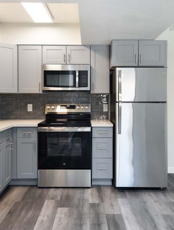 A modern kitchen with a stainless steel refrigerator and a black oven.