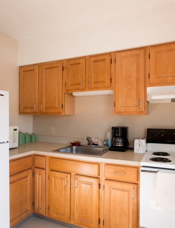a kitchen with white appliances and wooden cabinets