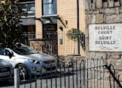 Thumbnail 3 of 5 - a car parked in front of a building with a sign