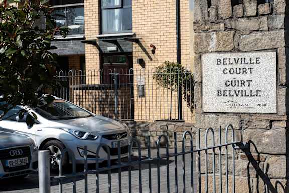 a car parked in front of a building with a sign