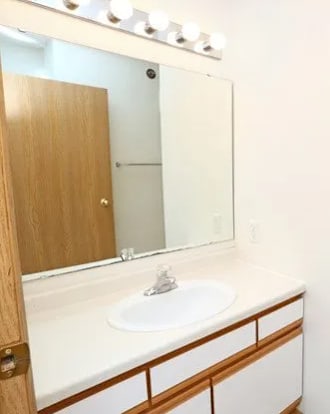A white toilet sits in a bathroom next to a sink.