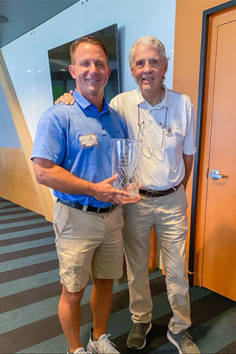 person receives his trophy from person