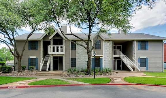 the view of an apartment building with stairs and trees at Polo Clubs Apartments, Austin, TX 78729