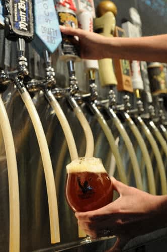 a person is holding a glass of beer