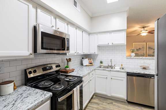 A kitchen with a stove, microwave, and refrigerator.