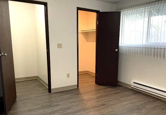 A room with a brown door and a white wall.