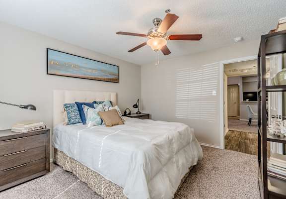 Bedroom with ceiling fan and walk-in closet at Amherst Apartments, Bedford, TX