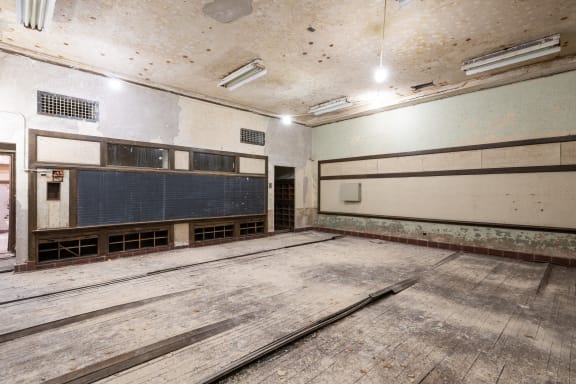 an empty gym with a wooden floor and a scoreboard