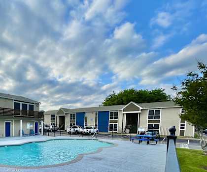 Swimming pool area with apartment buildings at Wymberly Crossing Apartments, Grand Prairie, 75052