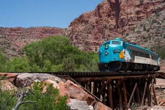 a blue train is going over a bridge
