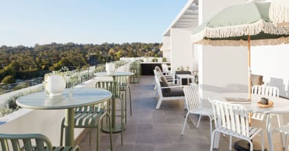 a terrace with tables and chairs and umbrellas on a roof