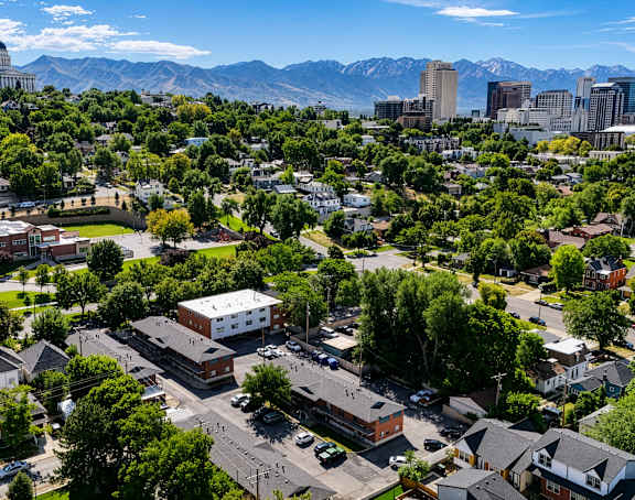 A cityscape with a mix of residential and commercial buildings, surrounded by mountains.