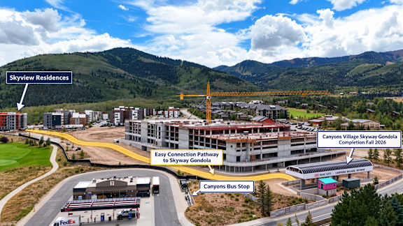 A picture of a road with a building and a sign that says Canyons Village Skyway Gondola.