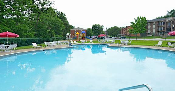 a swimming pool with chairs and umbrellas at a resort at Fairbrook Park, Baltimore, MD