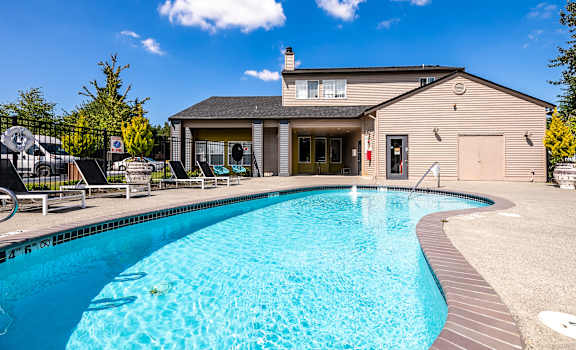 A swimming pool in front of a house.