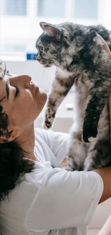a woman holding a cat up to her face