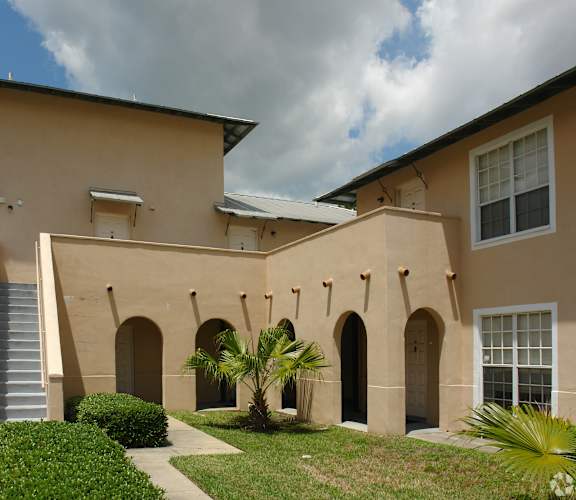 A beige building with a staircase leading to the entrance.