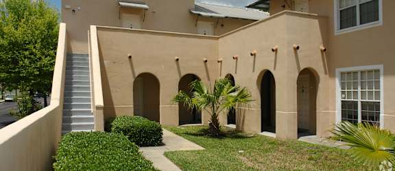 A beige building with a staircase leading to the entrance.