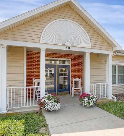 the front of a house with a porch and a blue door