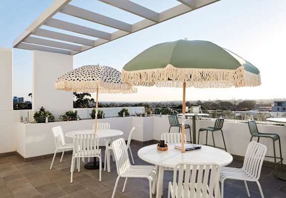a terrace with tables and umbrellas on a roof
